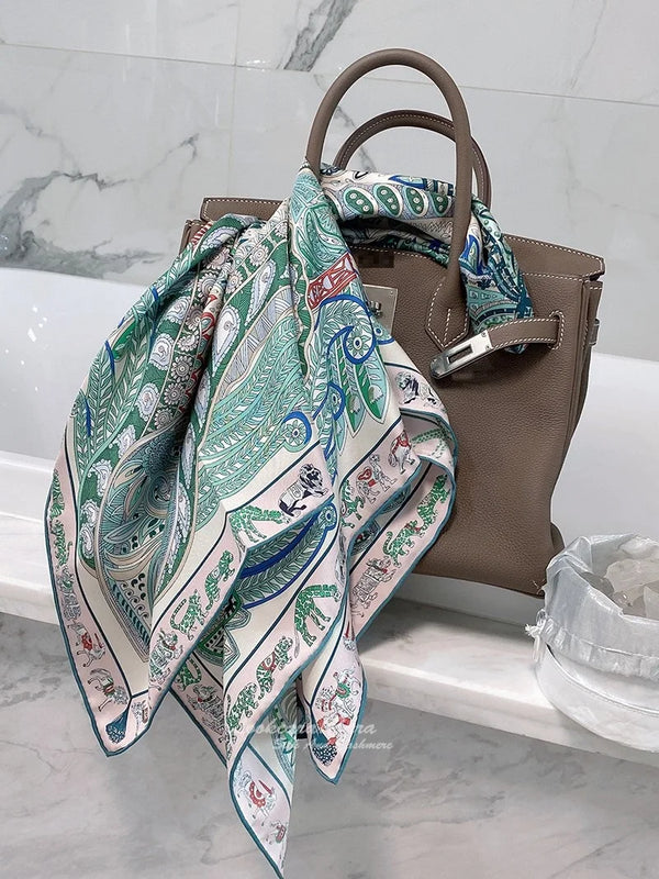 Elegant silk twill scarf styled as a head scarf for a chic look.