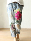Vintage floral embroidered high-waist denim jeans with loose fit, button fly, and enzyme wash for stylish casual wear.