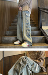 Full-length view of men's wide-leg jeans in coated denim.