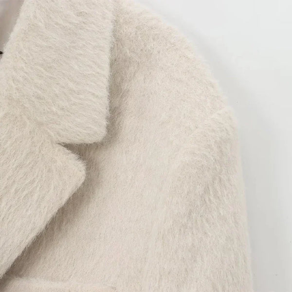 Close-up of turn-down collar and shoulder detail on creamy white mohair blazer