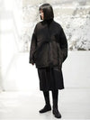 Cotton-linen padded jacket with cinched belt showing tailored waist silhouette