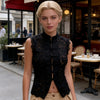 Detailed view of tatting craft lace pattern and unique frog button closures on black crop top