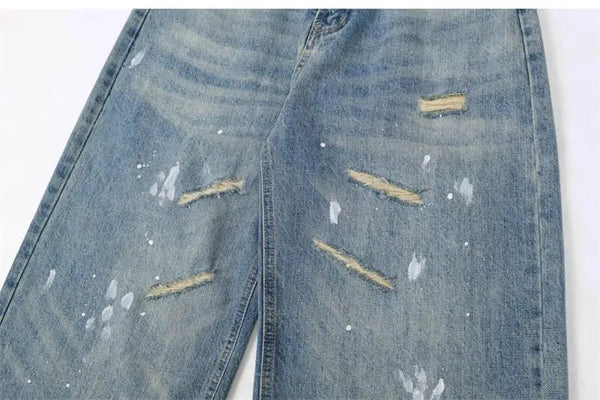 Trendy washed and ripped wide-leg women's jeans with distressed ink-splashed finish for a chic casual look.