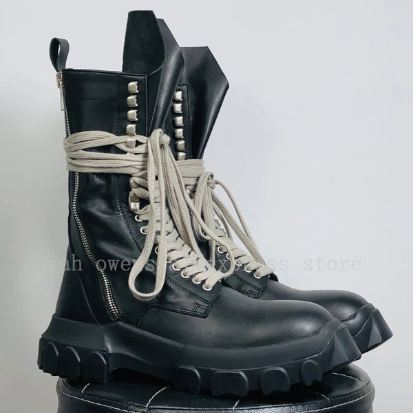 Top-down view of black designer high-top sneakers with rubber outsole.