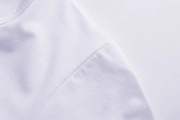 White graphic tee with motivational slogan styled with jeans for casual everyday wear