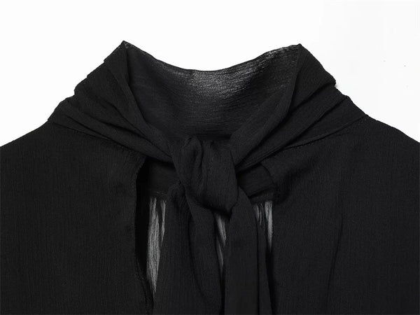 Sleeveless black polyester top with textured pleats and ribbon accent