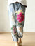 Vintage floral embroidered high-waist denim jeans with loose fit, button fly, and enzyme wash for stylish casual wear.