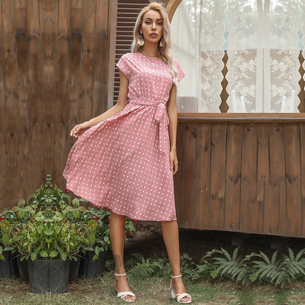 Side view of polka dot pleated midi dress showing flattering silhouette