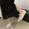 Close-up of embroidered ballet flats showing intricate bow detail and soft supple material