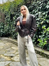 Chic belted leather bomber jacket for women, featuring a slim fit, lace-up detail, and hood for stylish autumn wear.