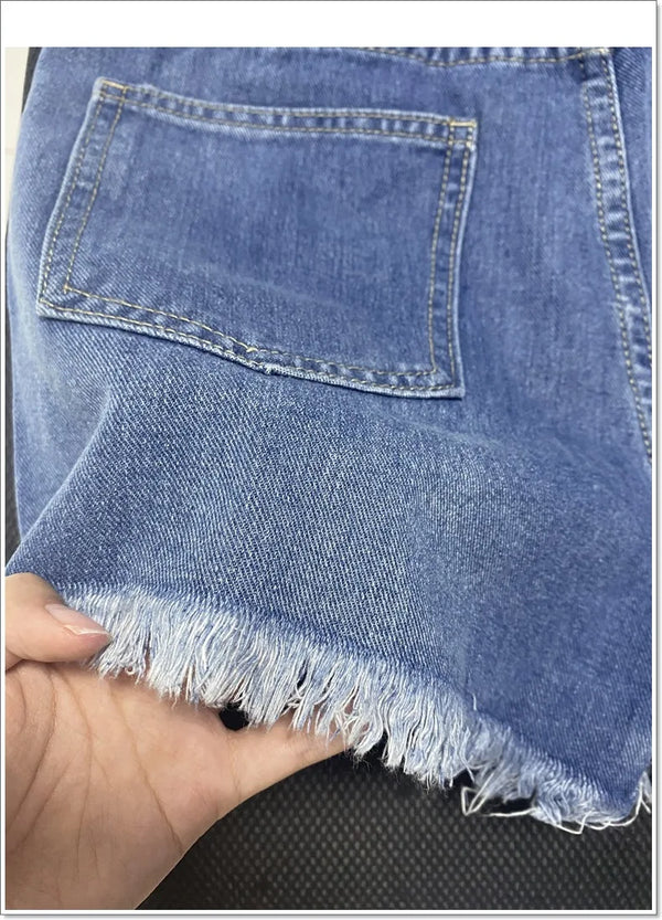 Button fly shorts in cotton blend with edgy rips and hand-finished fringe details