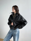 Chic vintage leather cropped jacket for women paired with elegant accessories.