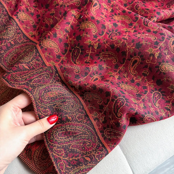 Sophisticated paisley pashmina draped over a casual outfit.