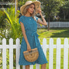 Woman wearing polka dot midi dress with belt tied at waist