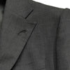 Close-up of Milanese lapel buttonhole and pick stitching on a luxury wool suit, highlighting fine details.
