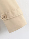 Beige short trench coat with classic belt and button styling