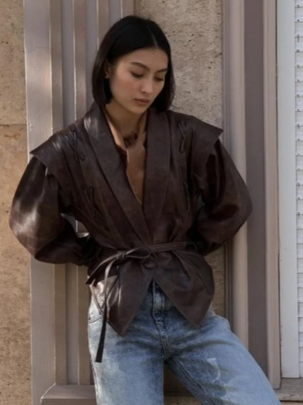 Chic belted leather bomber jacket for women, featuring lace-up detail, notched lapel, and hood for stylish autumn wear.