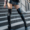 Model wearing elegant matte black stiletto over-the-knee boots at a party.