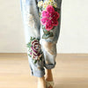 Vintage floral embroidered high-waist denim jeans with loose fit, button fly, and enzyme wash for stylish casual wear.