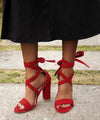 Trendy fuchsia stiletto sandals featuring a secure zipper closure.