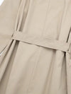 Close-up of adjustable sash belt and double-breasted buttons on trench coat