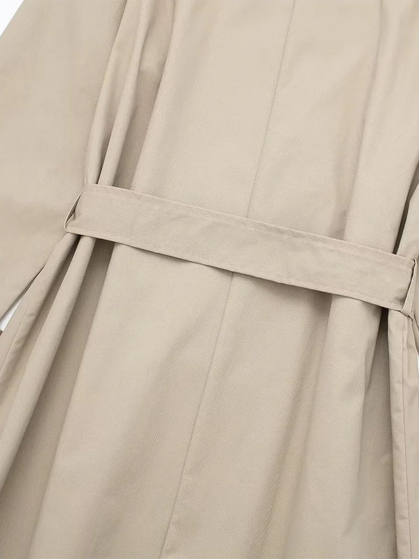 Close-up of adjustable sash belt and double-breasted buttons on trench coat