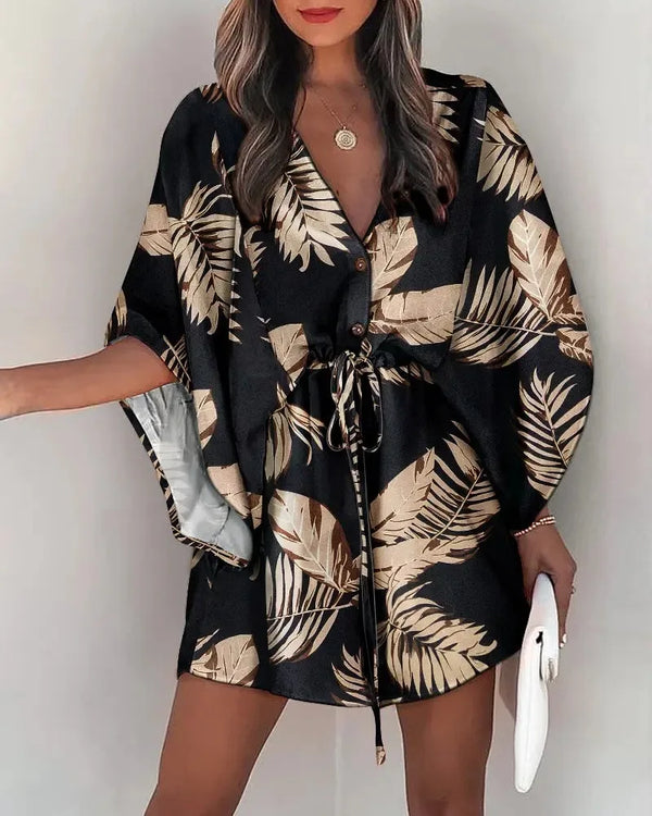 Woman wearing flowing floral print dress with asymmetrical ruffle hemline and relaxed fit