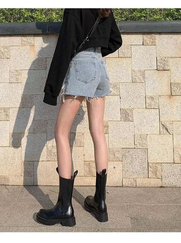 Blue jean shorts featuring high waist design and strategic ripped accents