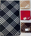 Elegant checkered wool-blend scarf displayed on a wooden table, highlighting its texture.
