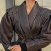 Chic belted leather bomber jacket for women, featuring lace-up detail, hood, and notched lapel, perfect for autumn and winter