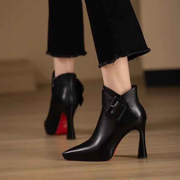 Side profile of pointed toe pump with belt buckle and five to eight centimeter heel