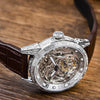 Timepiece of Triumph on a wooden table, highlighting its scratch-resistant sapphire crystal.