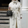 Cream polyester trench coat showing full drape and sophisticated silhouette