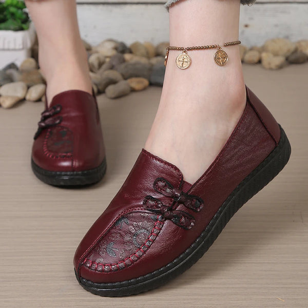 Women's slip-on leather loafers featuring cushioned insole and decorative flower detail