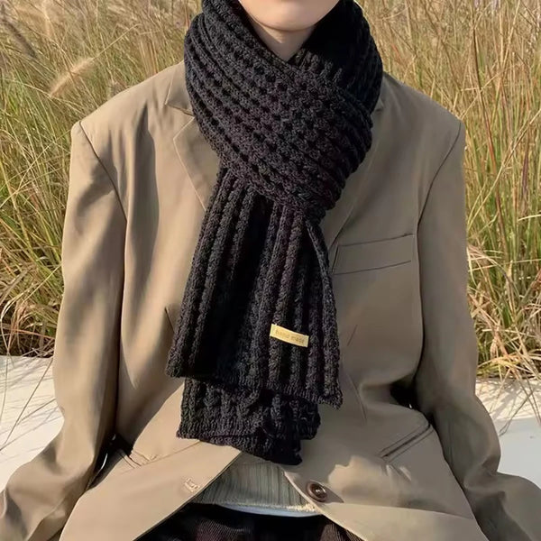 Stylish unisex chunky knit scarf draped elegantly over a winter coat.