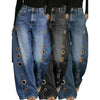Retro washed denim jeans featuring wide leg cut and modern metal grommet embellishments