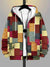 Close-up of plaid patchwork hoodie showing unique vintage pattern arrangement and zip front