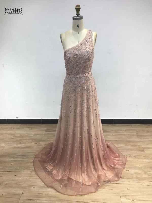 Flowing tulle skirt of the one-shoulder beaded gown, perfect for graceful movement.