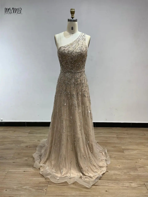Model showcasing the one-shoulder design of the beaded gown at a formal event.