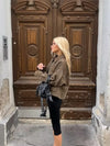 Chic women's leather jacket with button closure, lapel collar, and short length for stylish autumn fashion and urban style.