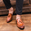 Side view of black tassel loafers showcasing their elegant silhouette.