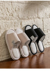 Linen slippers on wooden surface showing breathable material and solid pattern