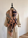 Luxury cashmere scarf folded neatly with floral accents.