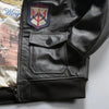 Close-up of the intricate embroidery on the chest of the leather bomber jacket.