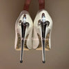Unique metal cross scepter heel design of crystal-embellished pumps.