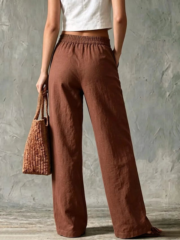 Woman wearing beige wide leg linen pants with button fly closure and side pockets