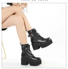 Black ankle boots displaying chain hardware and elevated platform construction