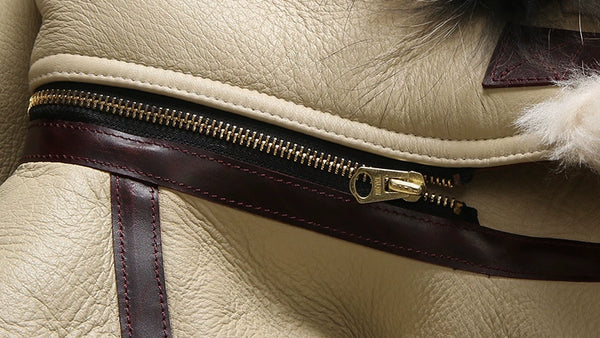 Luxury men's shearling leather bomber jacket folded neatly.