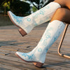 Embroidered mid-calf women's fashion boots with low wedge heel, slip-on design, and durable rubber outsole for comfort.