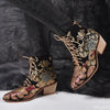 Women's embroidered ankle boots with golden floral patterns and secure lace-up closure